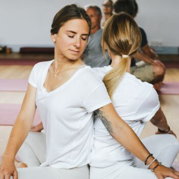 Yogaausbildung zwei junge Frauen üben den Drehsitz