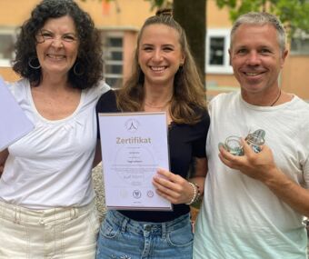Pascal Portmann und Nathalie Üstünay von Yoga Veda Ausbildungen mit einer Yogaschülerin die stolz Ihr Yogalehreinnen Zertifikat in den Händen hält