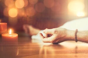 Hand im Kerzenlicht in der Tiefenentspannung - Yoga Nidra